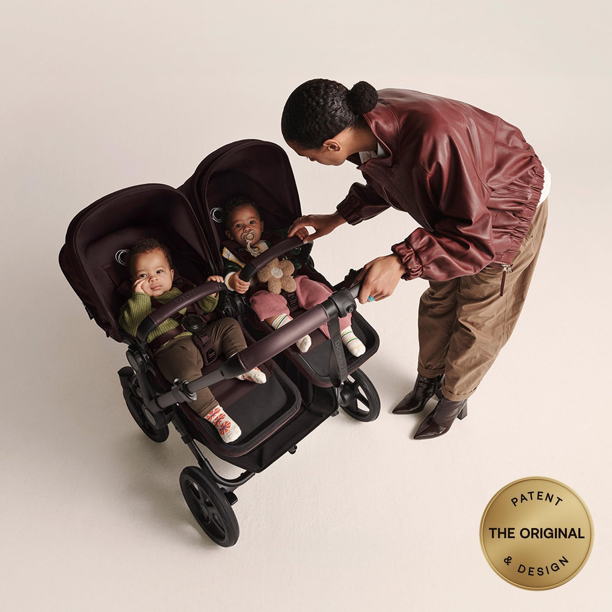 Bugaboo Donkey 6 Cocoa Brown side-by-side stroller for newborn and toddler, all-terrain design with adjustable seating options.