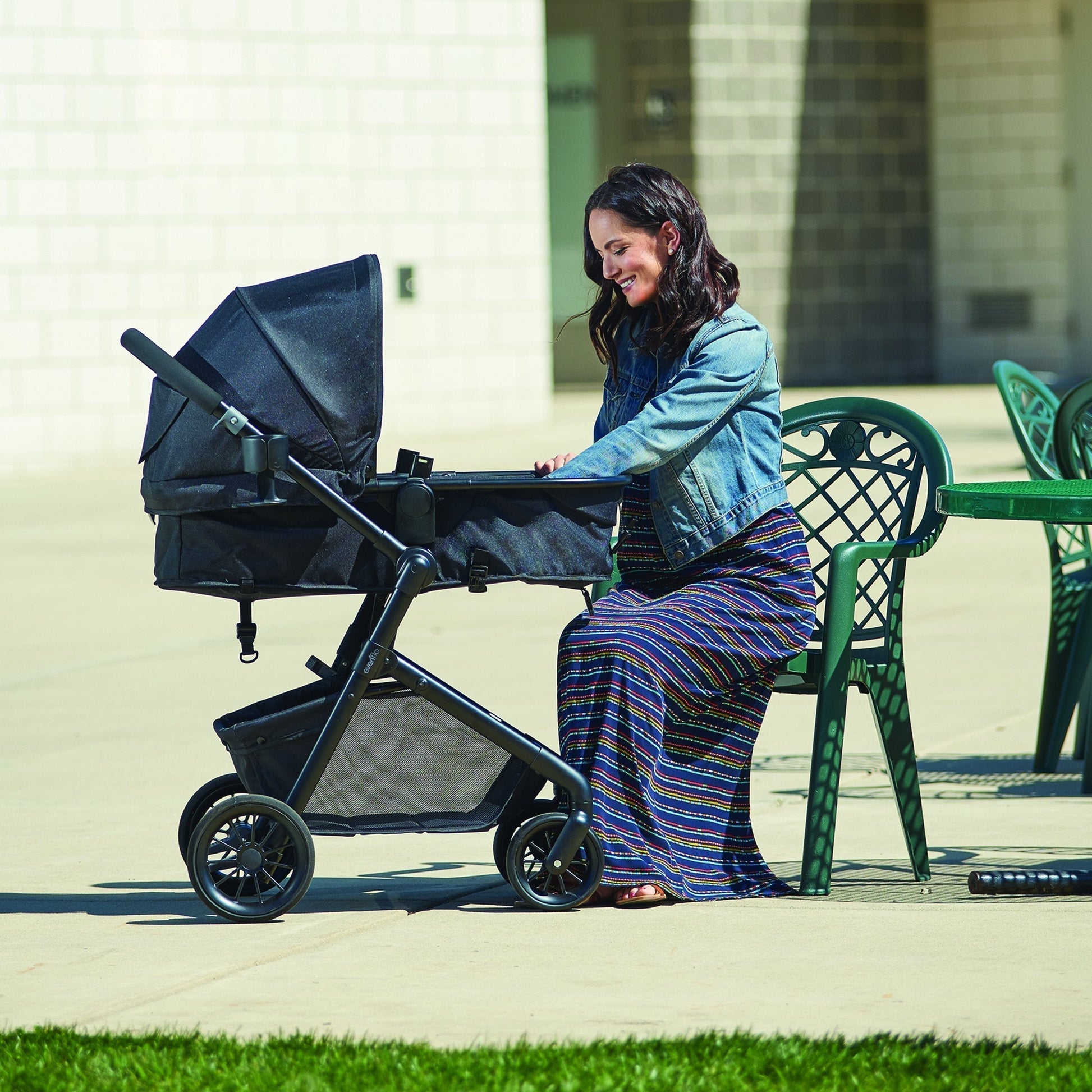Evenflo Pivot Modular Travel System with SafeMax Car Seat, stroller with car seat attached, featuring adjustable handle and storage basket.